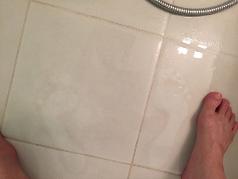 わかります？白髪染めシャンプー(グローリンワンクロス)をあわ立ててすすいだ後の風呂場のタイルに足跡がくっきり残っているくらい周りが薄茶色に染まっています。